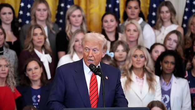 Donald Trump speaking with women behind him.