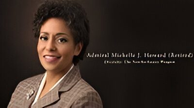 Portrait of a professional woman smiling against a dark background.